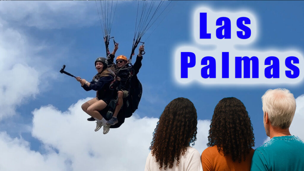 Paragliding in Gran Canaria with you family. A tandem pilot flies with passenger in front of dad and sisters